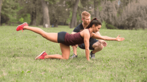 A personal trainer assisting a client doing exercise