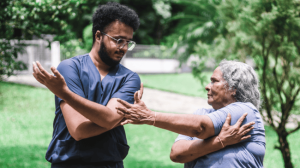 A personal trainer teaching a senior on how to do the workout