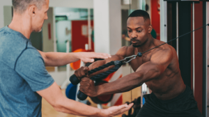 Personal trainer with boxing mitts spar with a trainee