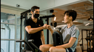 A personal trainer and a trainee doing fist bump