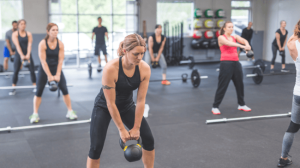 A woman lifting kettlebell together with other women